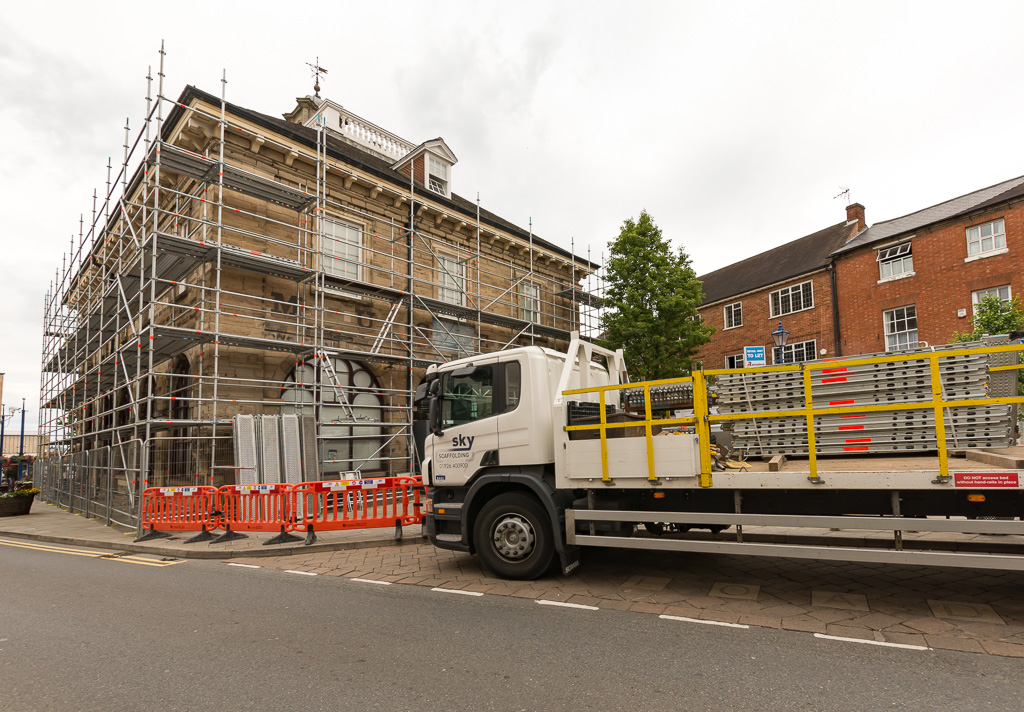Scaffold lorry with chapter 8 pedestrian barriers in front of a scaffold being installed oin a high street in Warwick